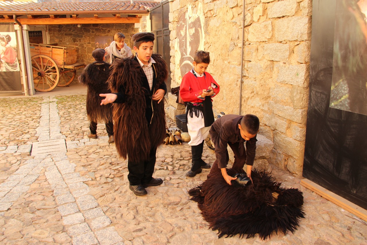 Young boys being dressed as Mamuthones in a village courtyard