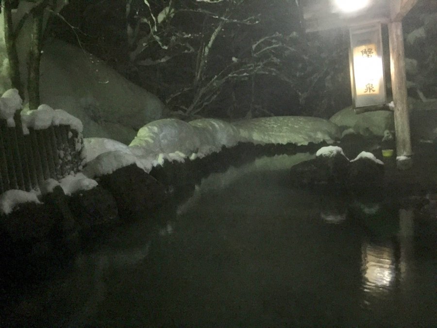 A natural outdoor onsen (rotenburo) in a mountain landscape
