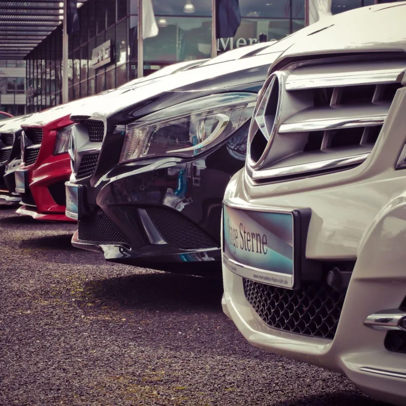 Luxury cars lined up at an outdoor dealership, showcasing sleek designs.